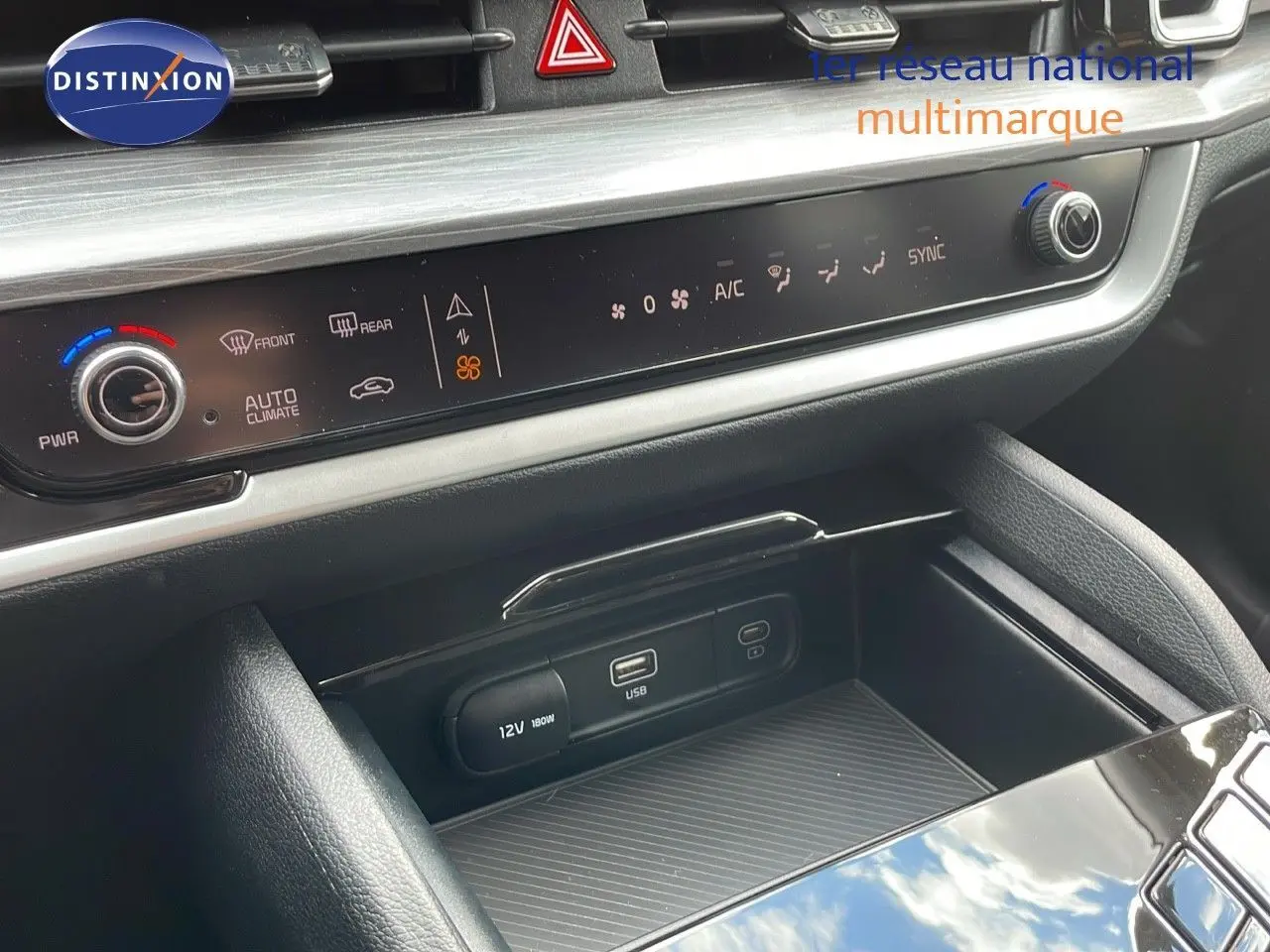 Détail de la console centrale du Kia Sportage 2025 gris foncé, montrant commandes climatisation et ports USB/12V.