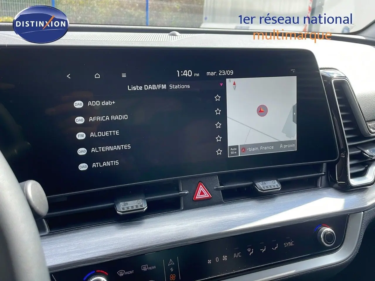 Écran tactile central du tableau de bord du Kia Sportage 2025, affichant la liste des radios et la navigation.