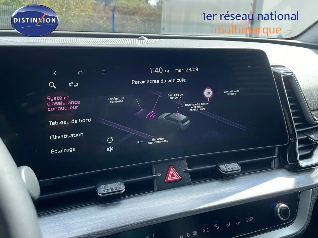 Vue intérieure centrée sur l'écran tactile du tableau de bord du KIA Sportage gris foncé 2025 avec affichage des aides à la conduite.