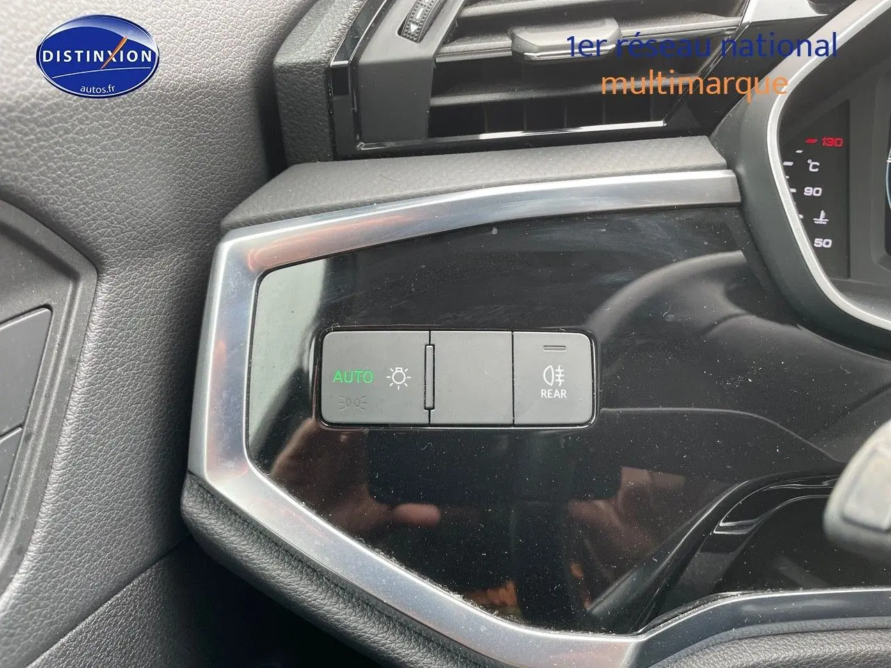 Gros plan sur les commandes d’éclairage à gauche du tableau de bord de l’Audi Q3 gris Chronos 2019.