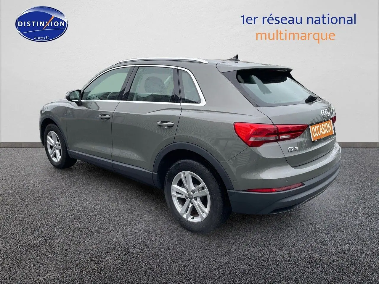 Audi Q3 gris Chronos métal vu de trois quarts arrière droit, mettant en valeur ses feux arrière et jantes alliage.