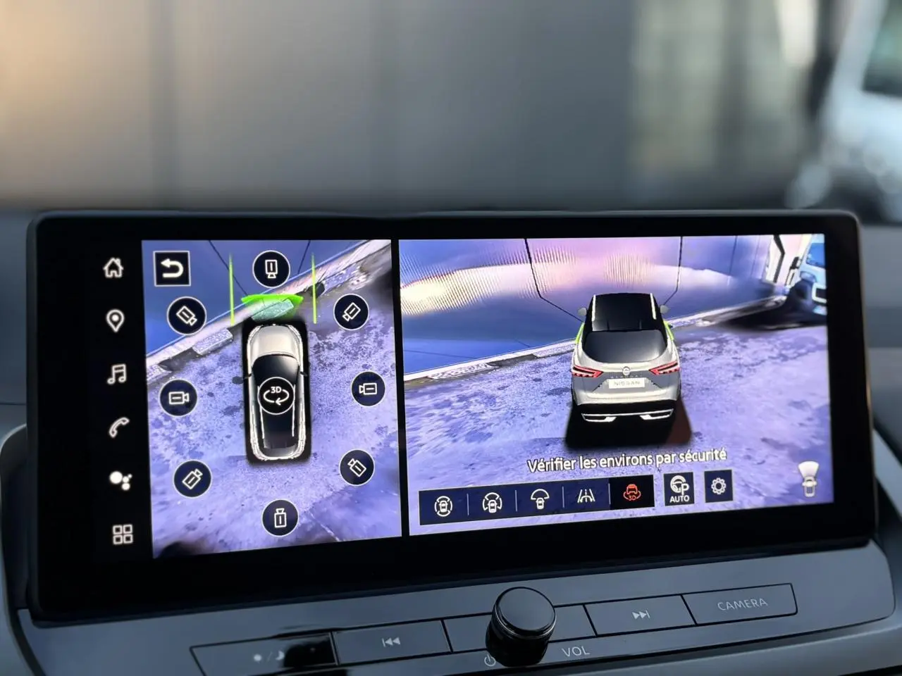 Écran de navigation affichant la vue 3D et arrière d’un Nissan Qashqai gris Ceramic en stationnement.