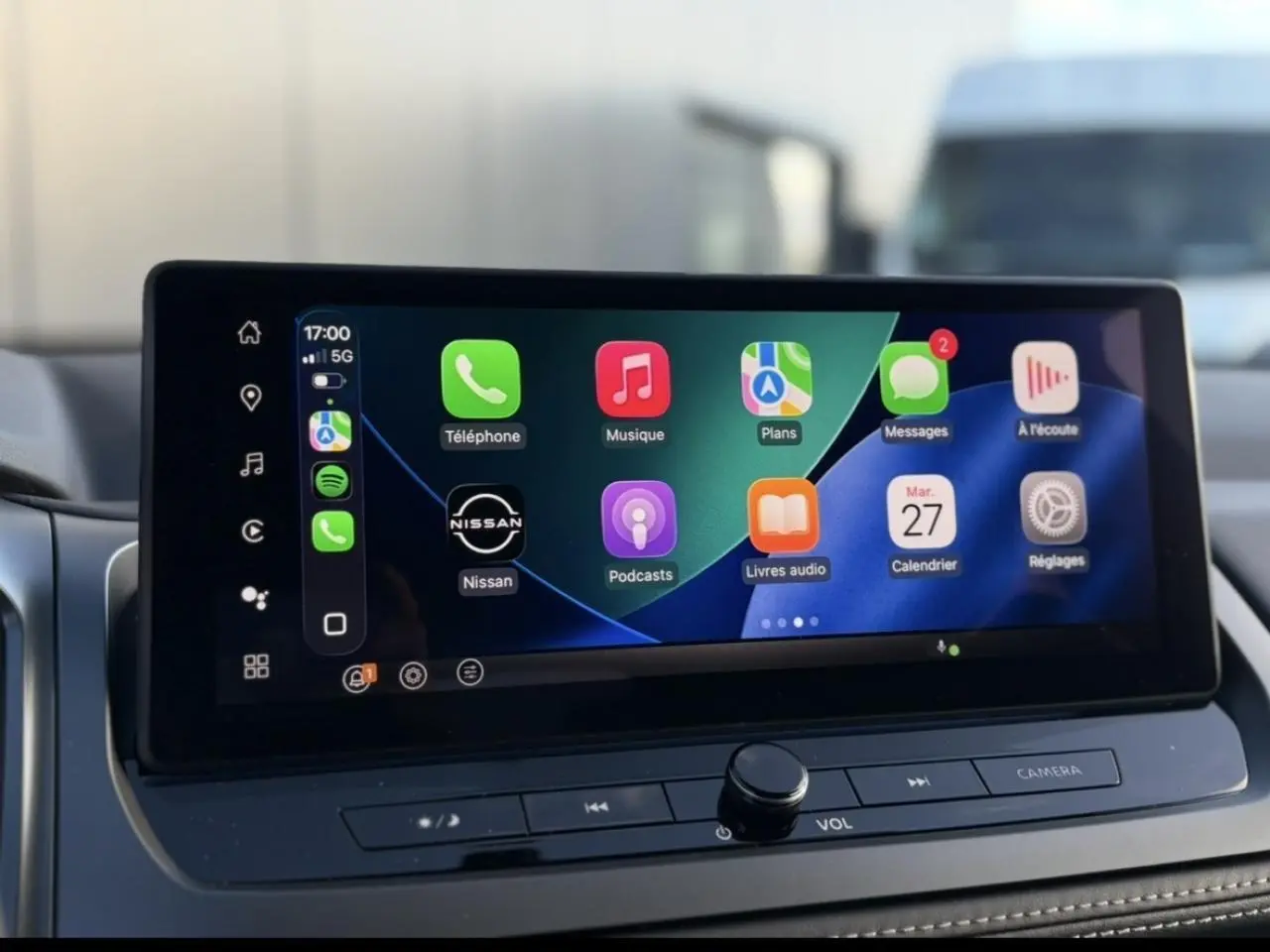 Écran tactile central du Nissan Qashqai 2025 affichant Apple CarPlay avec icônes colorées sur fond noir.