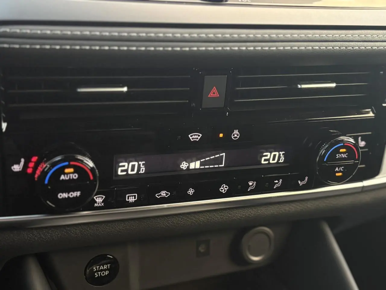 Gros plan sur la console centrale du Nissan Qashqai III gris Ceramic, affichant la climatisation automatique bi-zone à 20°C.