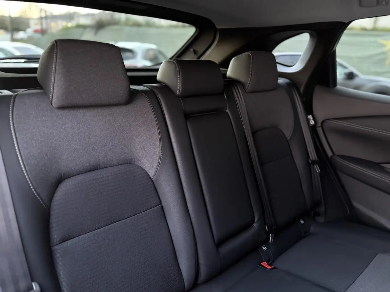 Vue intérieure des sièges arrière noirs du Nissan Qashqai III e-Power 2025, avec appuie-têtes et ceintures visibles.