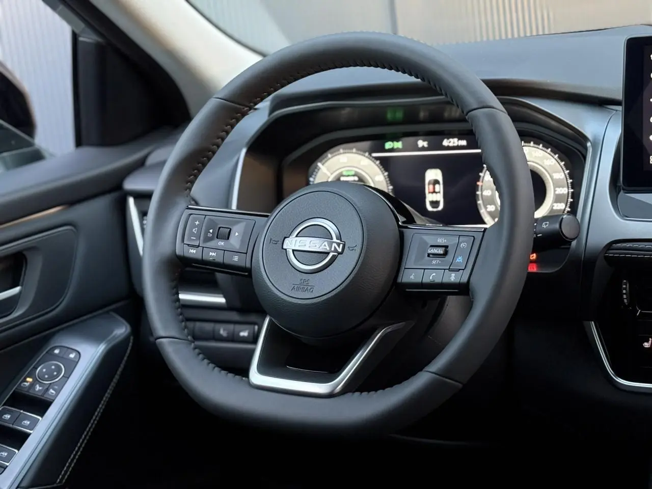 Vue rapprochée du volant cuir noir du Nissan Qashqai 2025 avec tableau de bord numérique et commandes intégrées.
