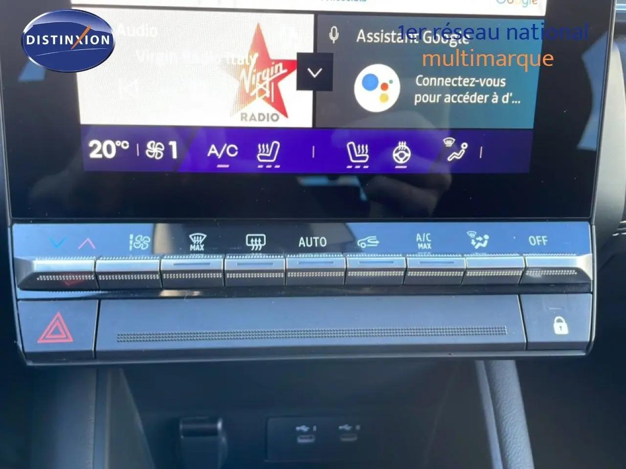 Gros plan sur la console centrale tactile et les commandes climatisation du Renault Symbioz bleu iron metal, version hybride 2025.
