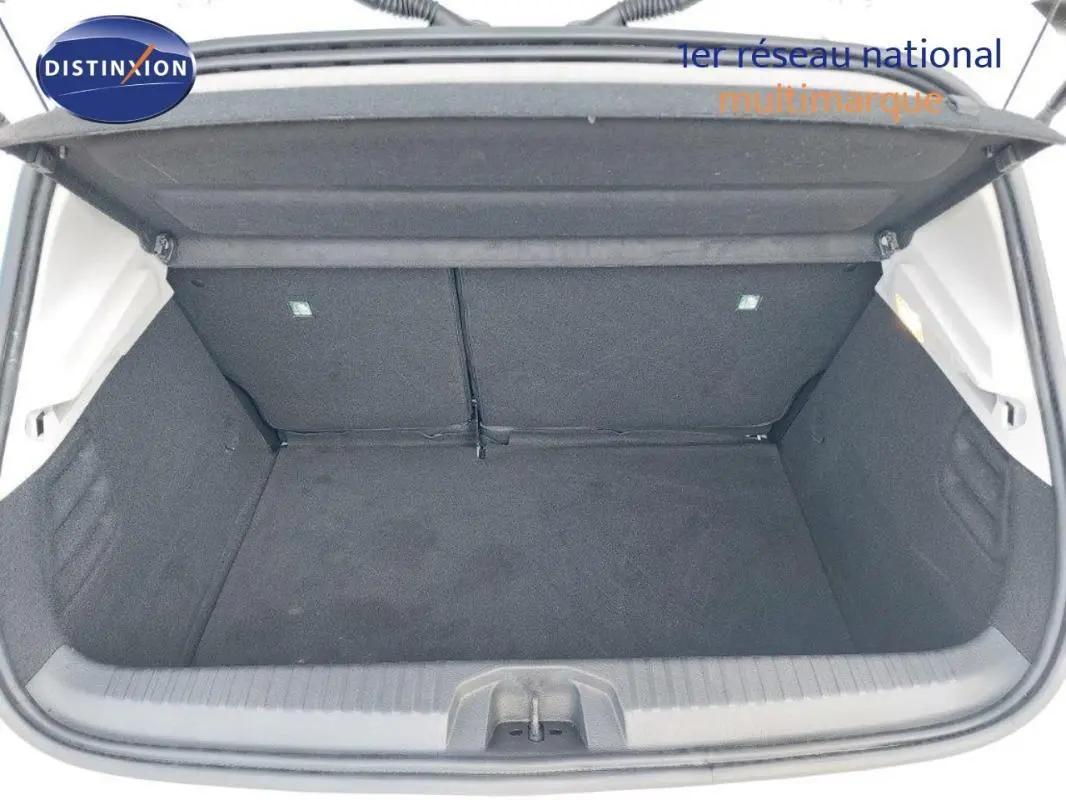 Coffre ouvert de la Renault Clio blanc vue de l'arrière, montrant un espace de chargement propre et spacieux.