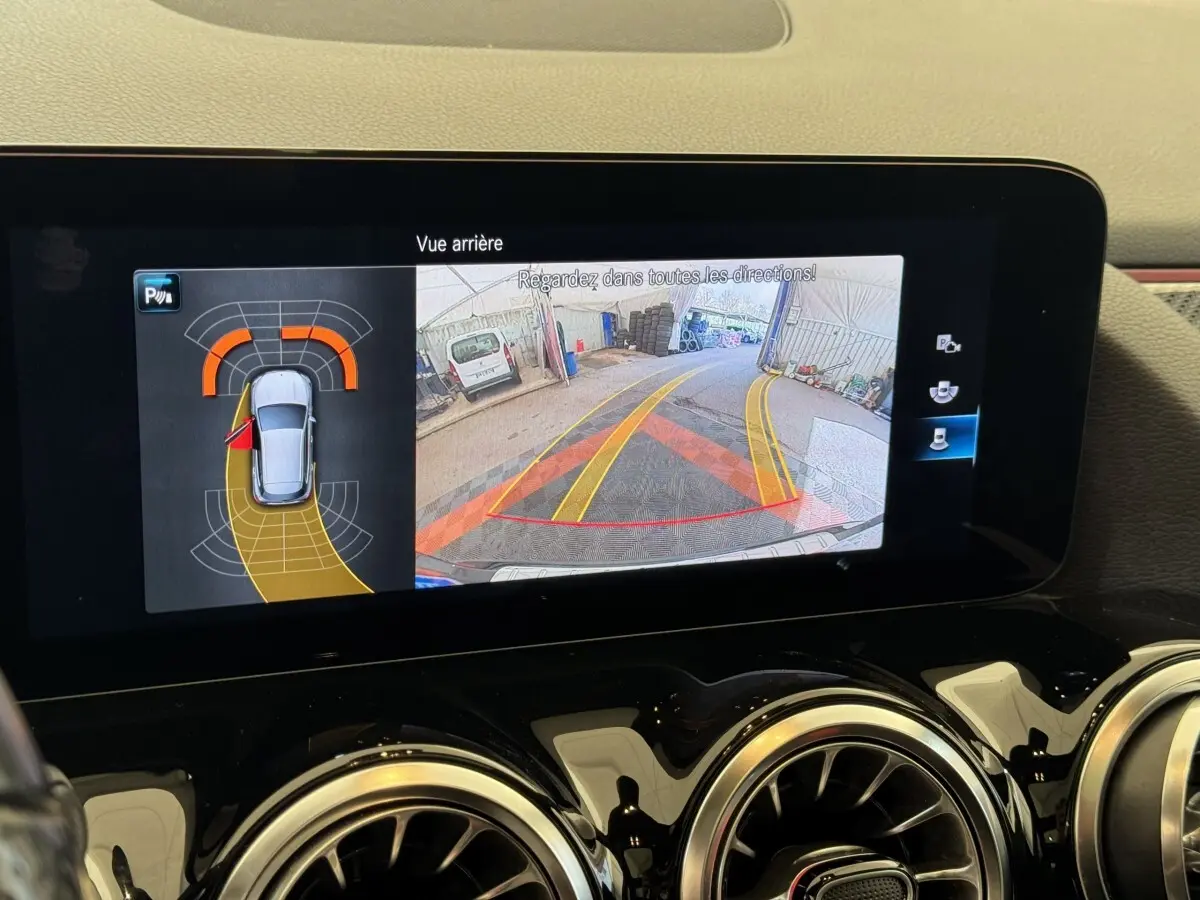Écran intérieur affichant la caméra de recul et capteurs de stationnement du Mercedes GLA 250 e AMG Line noir, vue arrière.