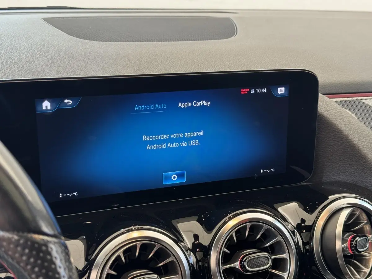 Vue intérieure du tableau de bord noir d'une Mercedes GLA 250 e AMG Line 2021 avec écran tactile central allumé.