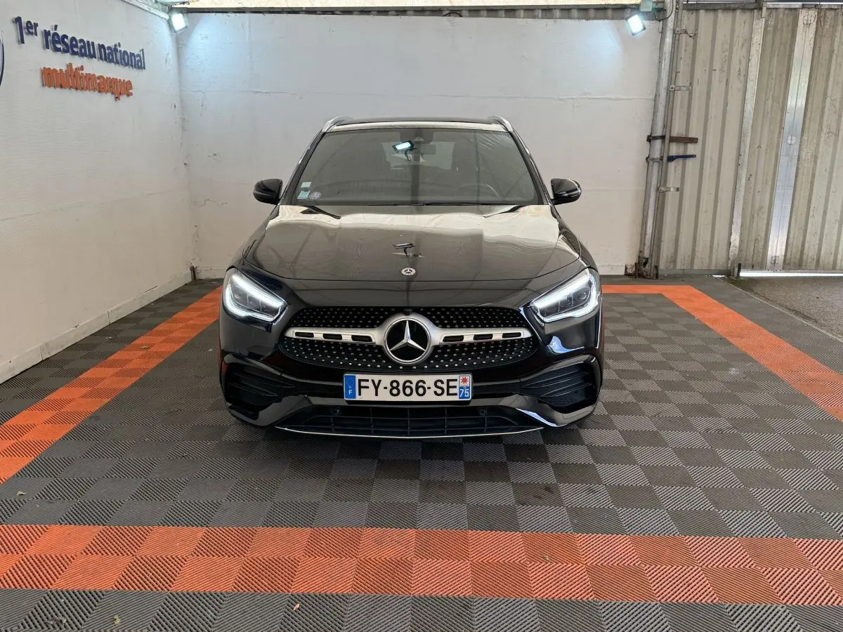 Vue avant d’un Mercedes GLA 250 e AMG Line noir avec phares LED allumés, calandre étoilée et plaque d’immatriculation française.