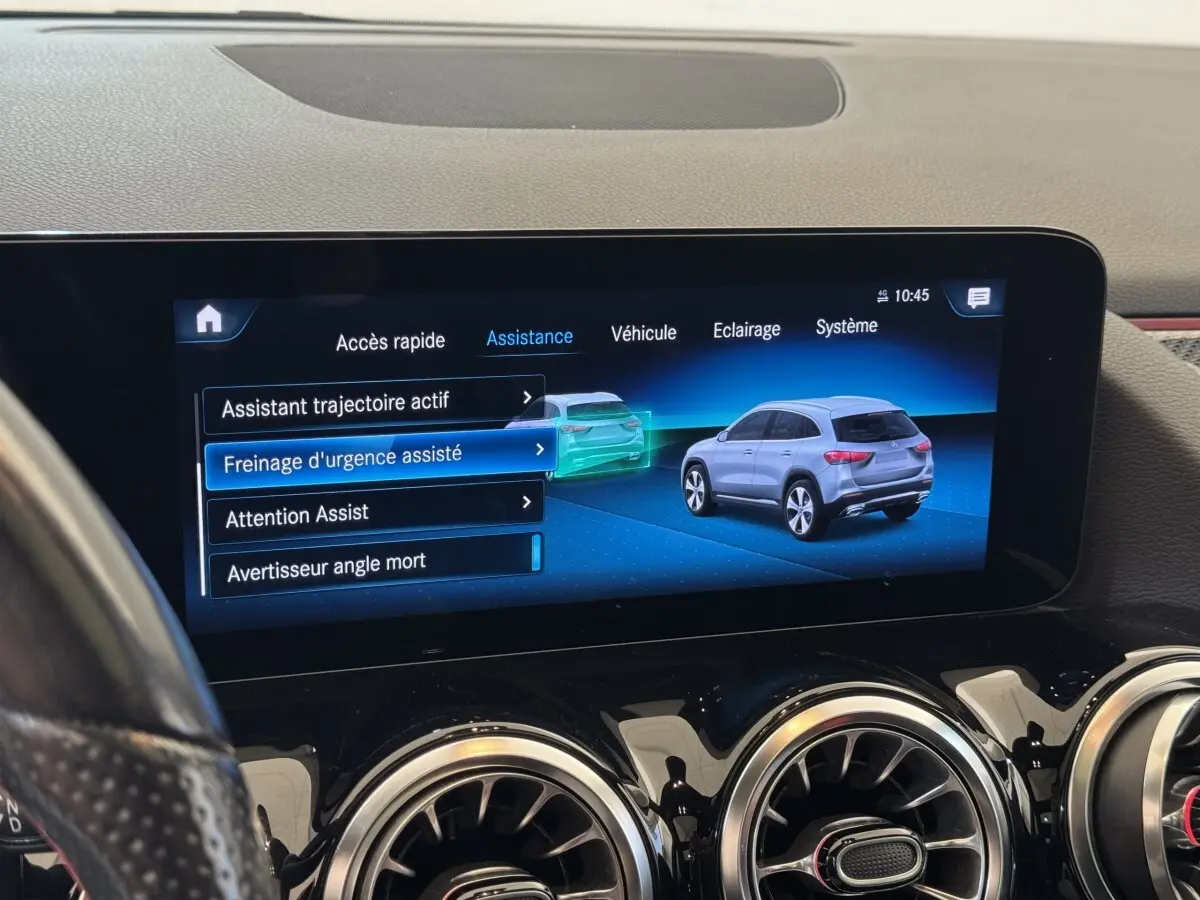 Écran tactile central affichant les aides à la conduite avec illustration d’un SUV Mercedes GLA gris en vue arrière 3/4.