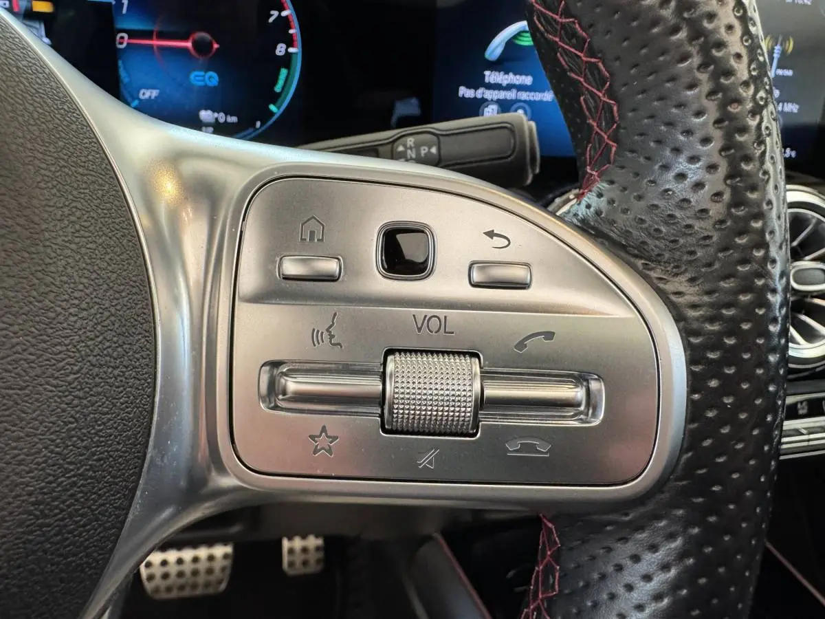 Gros plan sur les commandes multifonctions en métal et cuir perforé du volant du Mercedes GLA 250 e AMG Line noir, 2021.