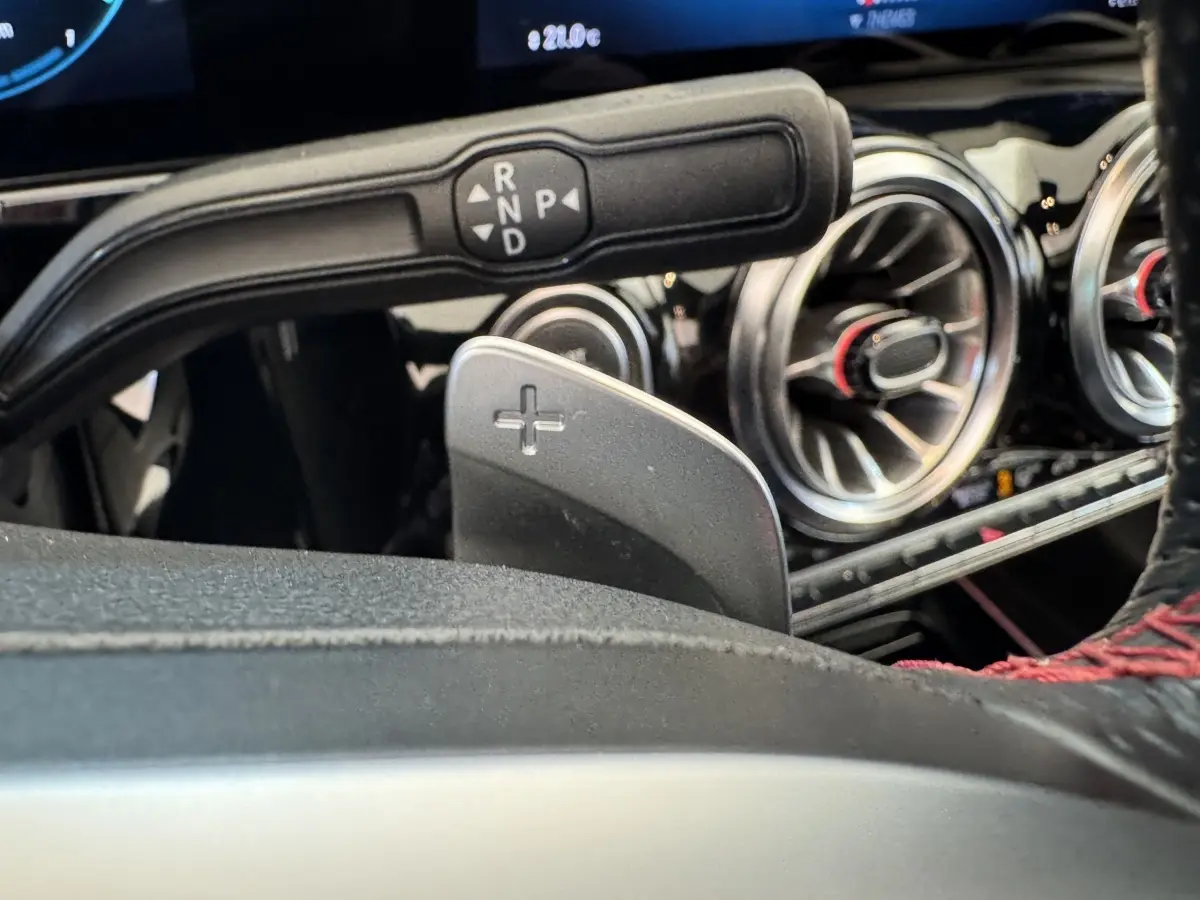 Gros plan sur la palette de changement de vitesse droite et commandes autour du volant d’un Mercedes GLA 250 e AMG Line noir.