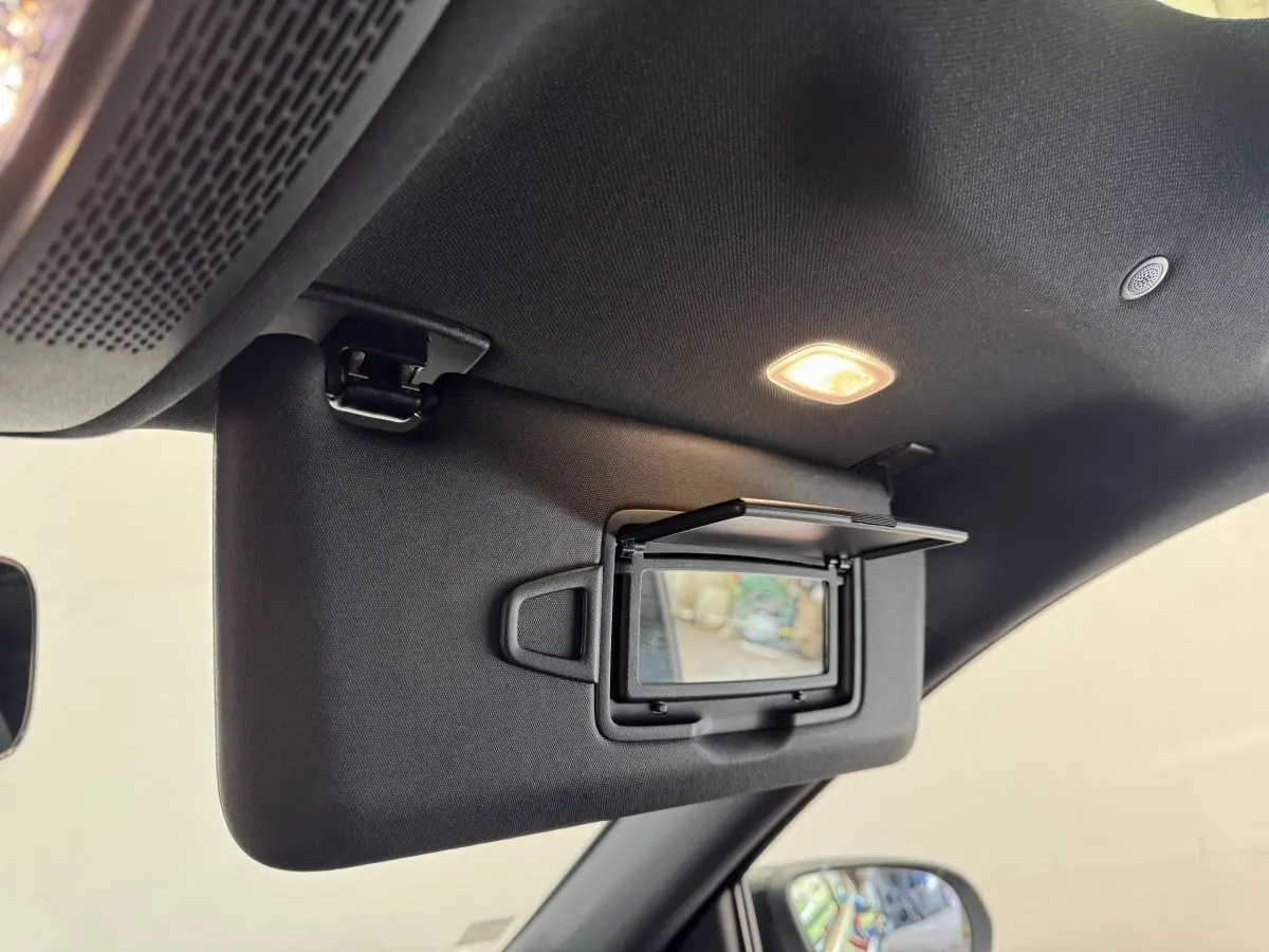 Détail intérieur du pare-soleil côté conducteur avec miroir éclairé dans un Mercedes GLA noir 2021.
