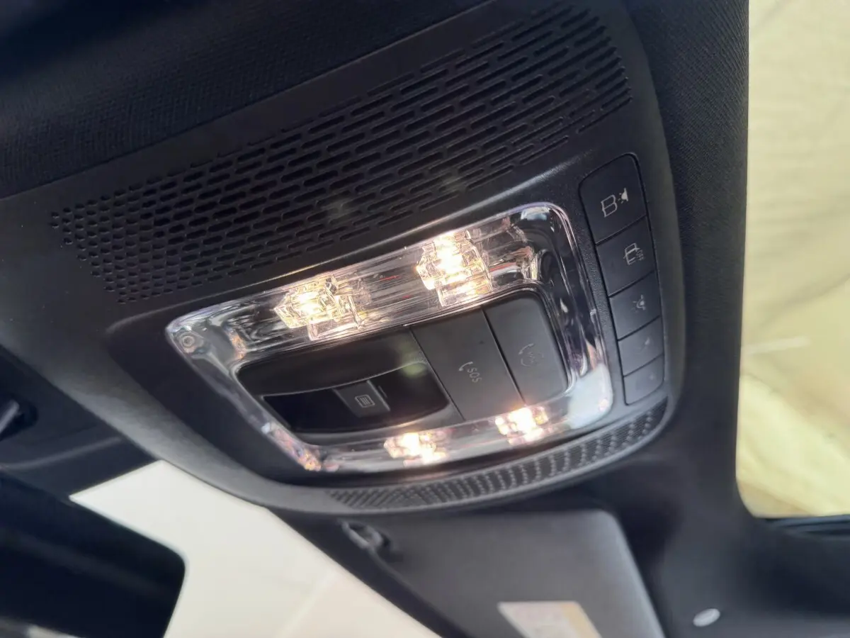 Plafonnier intérieur allumé avec commandes SOS et éclairage, vue du toit d’un Mercedes GLA 250 e AMG Line noir.