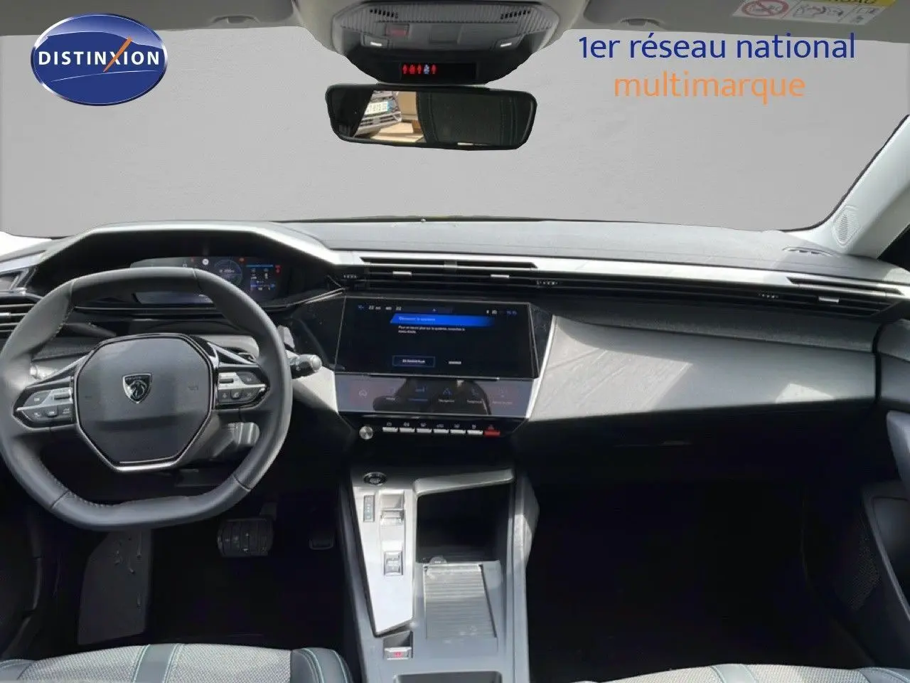 Vue intérieure avant du Peugeot 308 SW Hybrid 145ch Allure 2025, tableau de bord noir avec écran tactile central et volant multifonction.