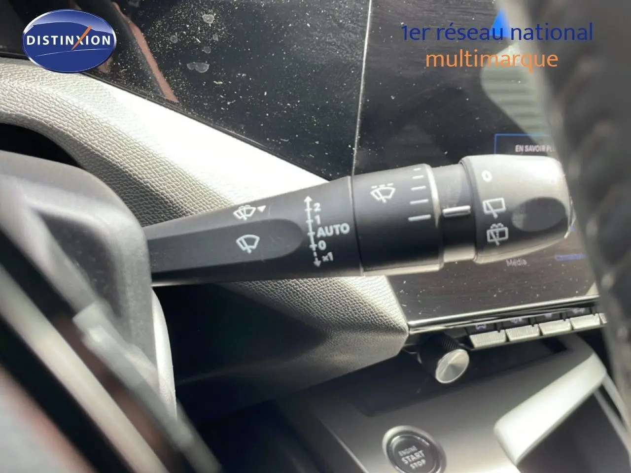 Gros plan sur la commande d'essuie-glace à gauche du volant dans l'habitacle d'une Peugeot 308 SW noir métal 2025.