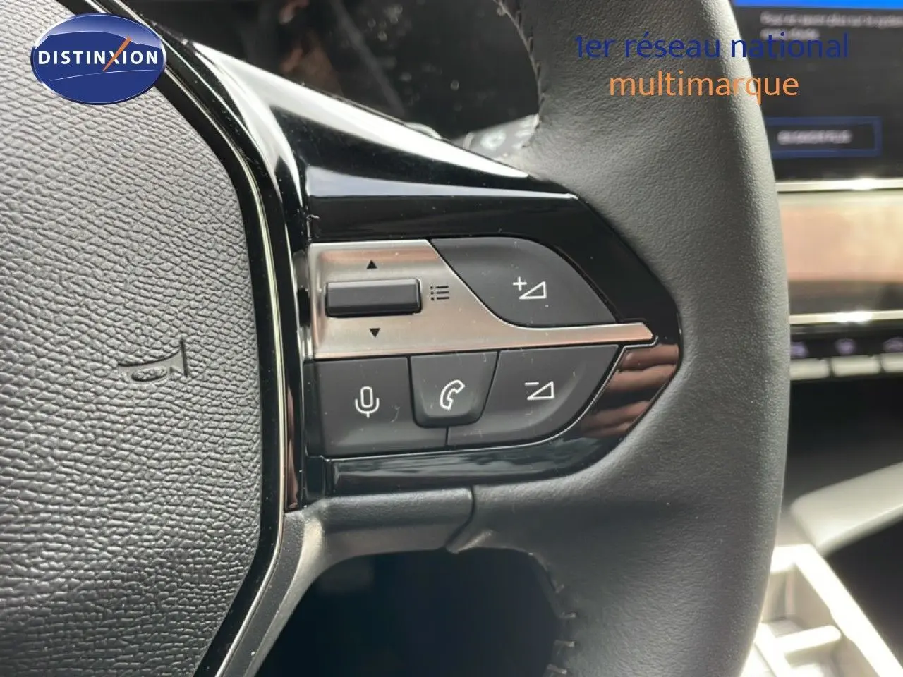 Gros plan sur les commandes du volant noir de la Peugeot 308 SW Hybrid 145ch Allure, intérieur gris noir.