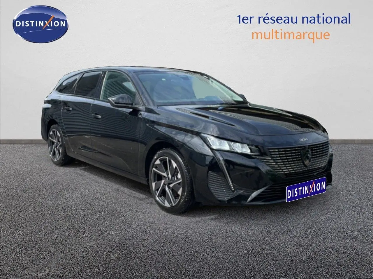 Peugeot 308 SW noir métal en 3/4 avant droit, break hybride avec jantes alliage distinctives.