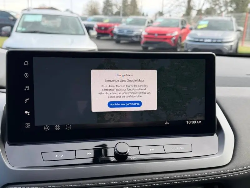 Écran tactile central du Nissan Qashqai Hybrid e-POWER 2025 affichant Google Maps, avec commandes audio et bouton caméra visibles.