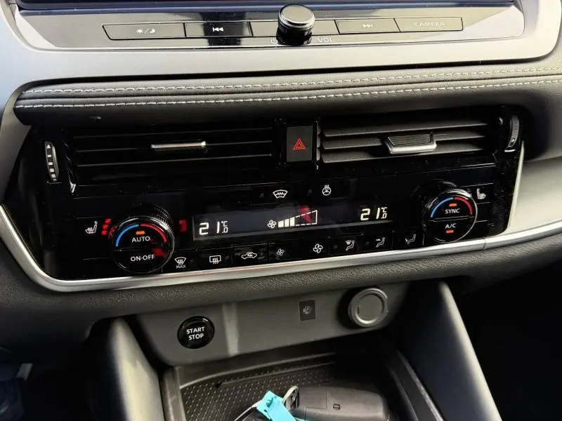 Détail du tableau de bord du Nissan Qashqai Hybrid e-POWER 2025, avec commandes climatisation et bouton start/stop.