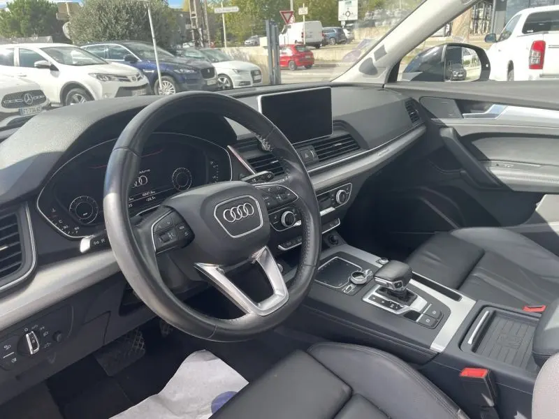 Intérieur de l'Audi Q5 2.0 TFSI 252 AVUS 2017, vue côté conducteur, tableau de bord noir avec écran central et volant multifonction.