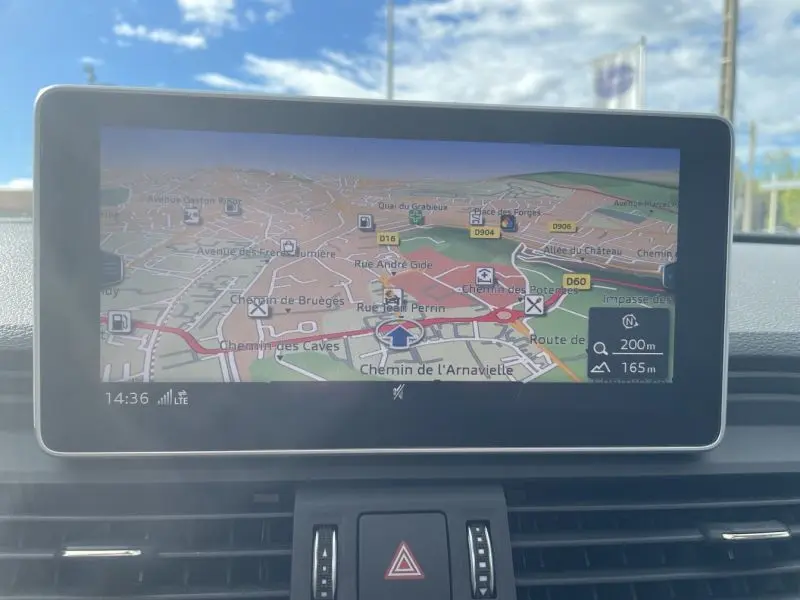 Écran de navigation intégré au tableau de bord d'un Audi Q5 noir métal 2017, affichant une carte détaillée.
