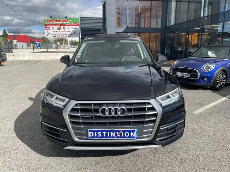 Audi Q5 2.0 TFSI noir métal vu de face, avec calandre chromée et logo Audi bien visible.