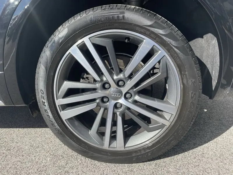 Gros plan sur la roue avant droite d'un Audi Q5 noir métal 2017, mettant en valeur la jante alliage et le pneu Pirelli.