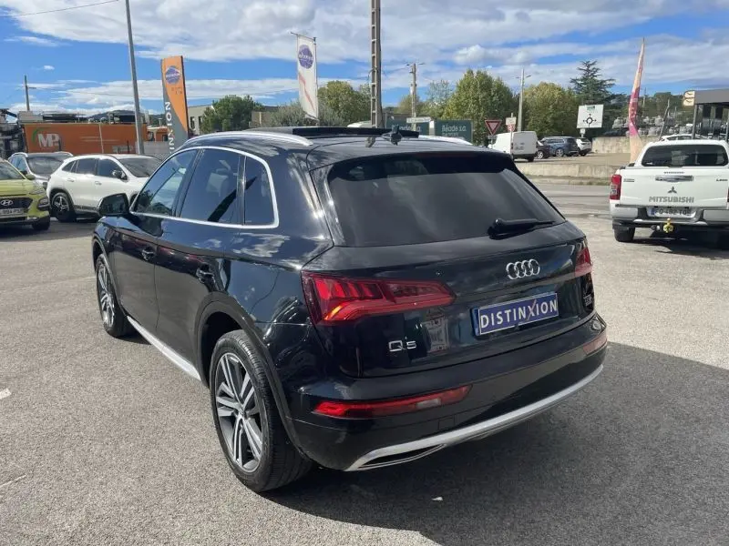 Audi Q5 noir métal vu en 3/4 arrière droit, avec feux arrière LED et jantes alliage distinctives.