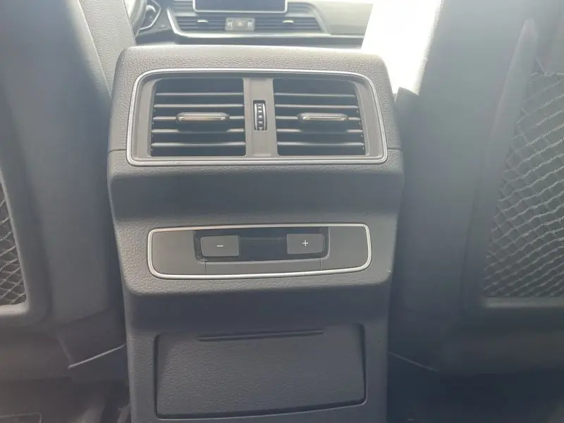 Vue rapprochée de la console arrière noire métal d’un Audi Q5 2.0 TFSI 252 AVUS avec commandes de ventilation.