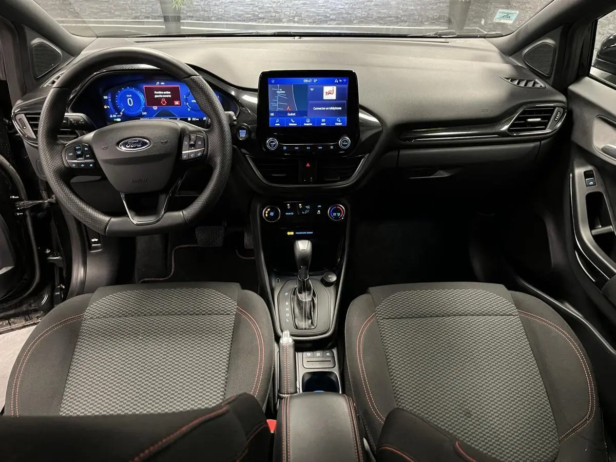 Vue intérieure avant du Ford Puma 2023 noir avec tableau de bord numérique et console centrale moderne.
