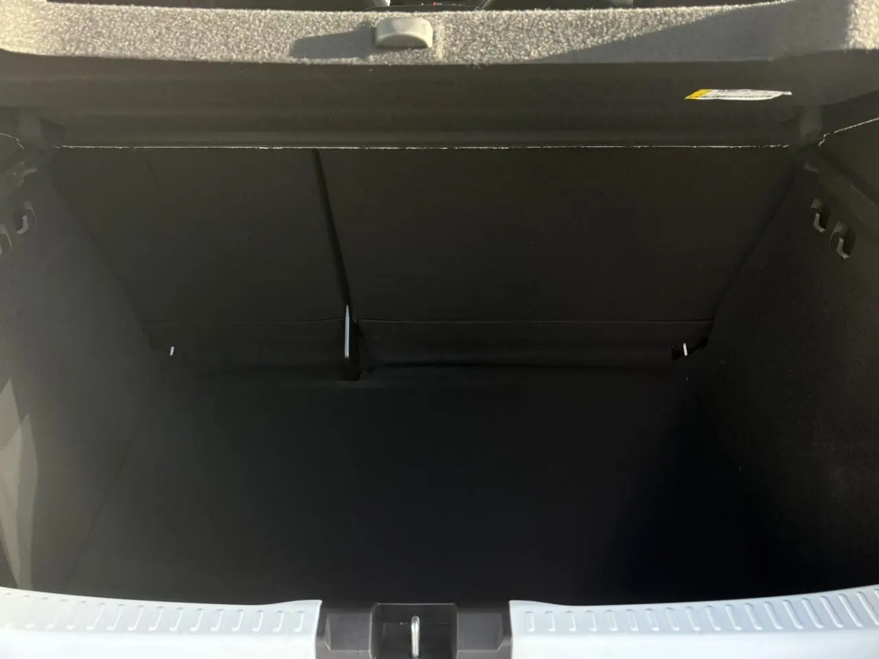 Coffre ouvert noir spacieux du Dacia Sandero Stepway 2024, vue intérieure arrière sans chargement visible.