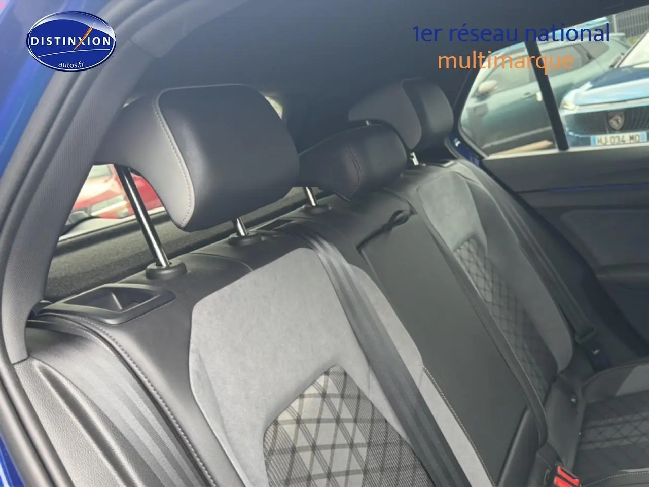 Vue intérieure de la banquette arrière en tissu gris et cuir noir de la Volkswagen Golf 2024 côté droit.