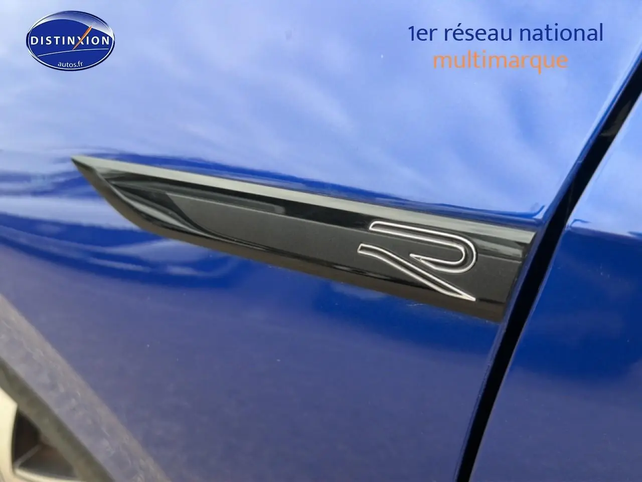 Détail de l'emblème R noir sur la porte côté gauche d'une Volkswagen Golf bleue 2024.