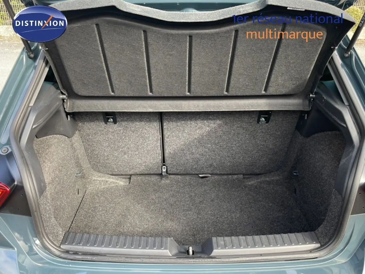 Coffre ouvert vu de l'arrière d'une SEAT Ibiza bleu Fjord, montrant un espace de rangement propre et tapissé.