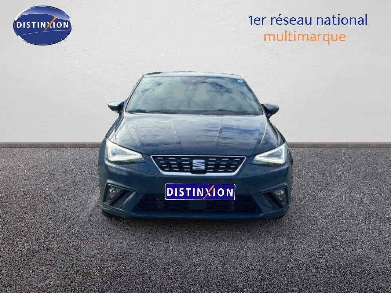 Vue frontale d'une SEAT Ibiza 2025 bleu fjord avec phares LED allumés sur fond neutre.