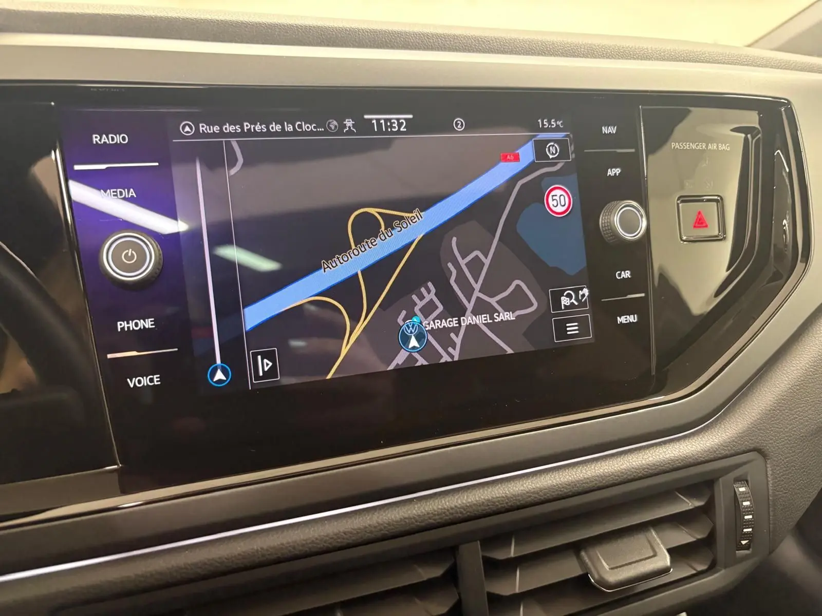 Écran tactile central du Volkswagen Taigo 2024 affichant la navigation, entouré de commandes noires brillantes.