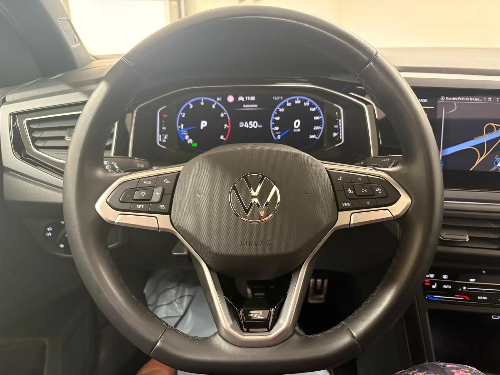 Vue intérieure centrée sur le volant noir du Volkswagen Taigo 2024 avec tableau de bord digital et écran tactile.