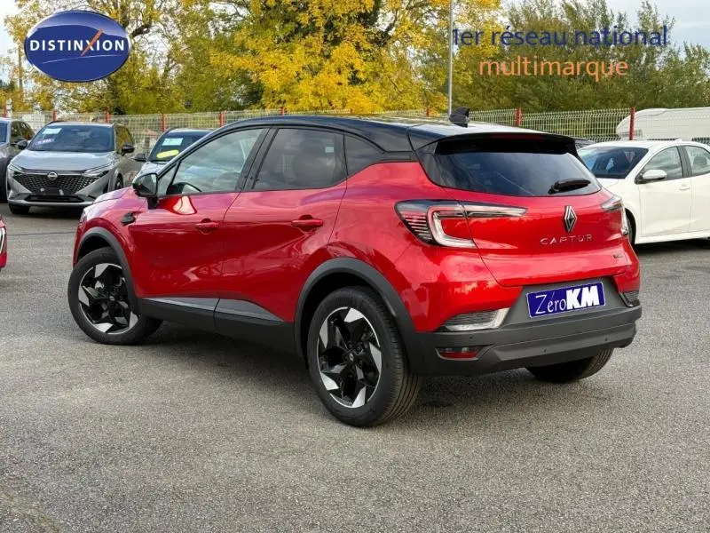 Vue 3/4 arrière droite d'un Renault Captur 2025 rouge Flamme avec toit noir et jantes alu noires.