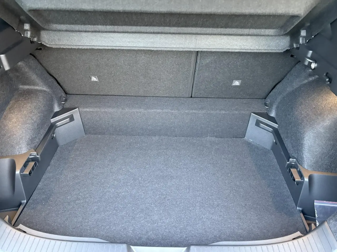 Vue intérieure du coffre spacieux et modulable du Nissan Qashqai III e-Power en gris Ceramic, avec revêtement sombre.