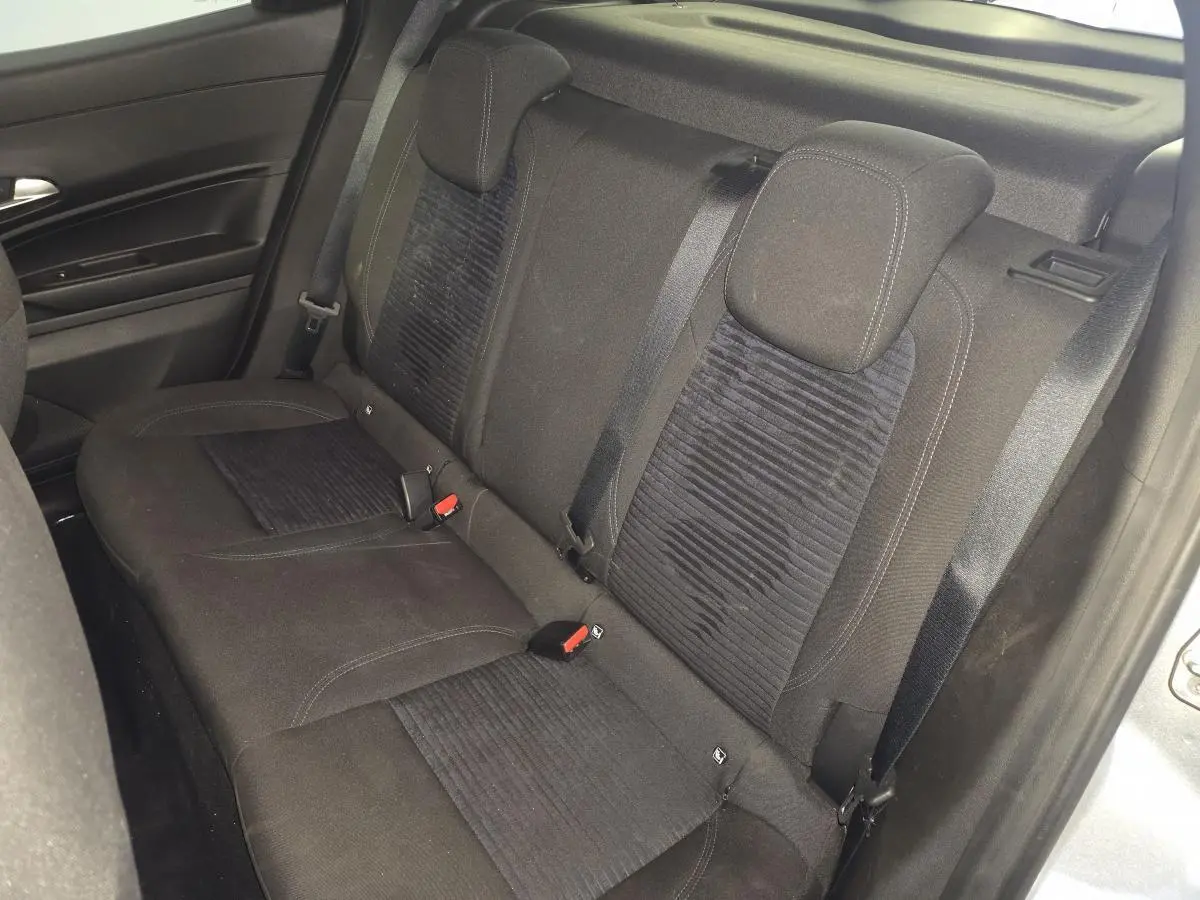 Vue intérieure de la banquette arrière noire de l'Alfa Romeo Junior 1.2 Ibrida 2025, avec ceintures de sécurité visibles.