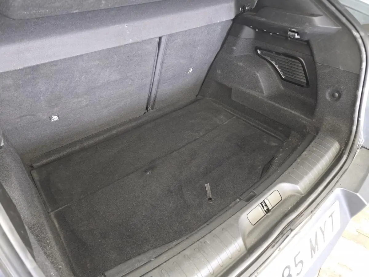 Coffre ouvert vu de l'arrière d'une Alfa Romeo Junior gris métallisé, montrant l'espace de chargement vide.