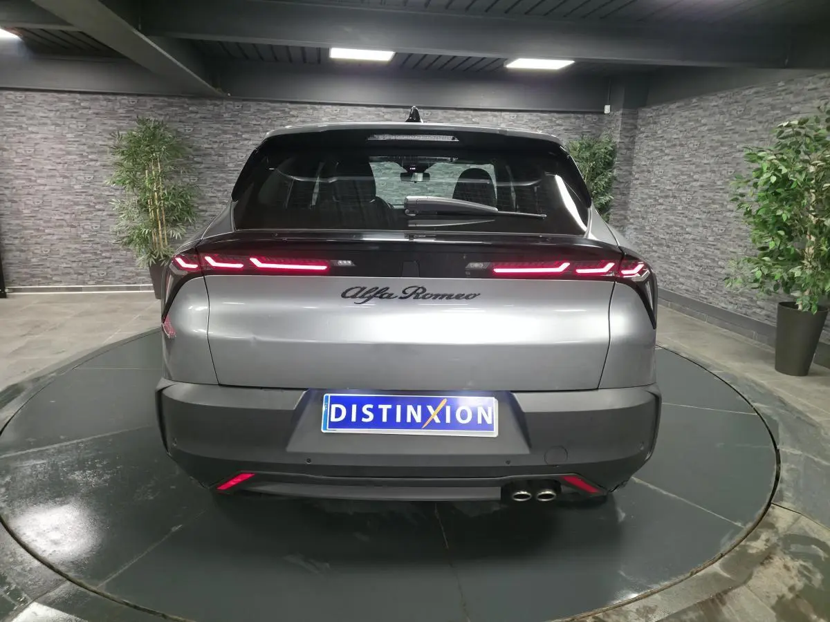 Vue arrière d'une Alfa Romeo Junior 1.2 hybride gris métallisé avec feux arrière LED et double sortie d'échappement.