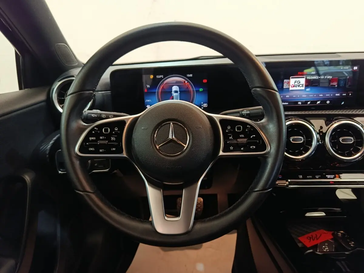 Vue intérieure centrée sur le volant cuir noir de la Mercedes Classe A 200 Business Line avec tableau de bord numérique.