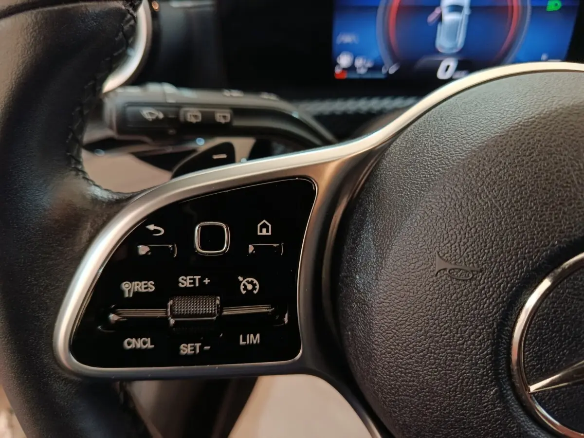 Gros plan sur le volant cuir noir de la Mercedes Classe A 200 Business Line 2021, avec commandes multifonctions intégrées.