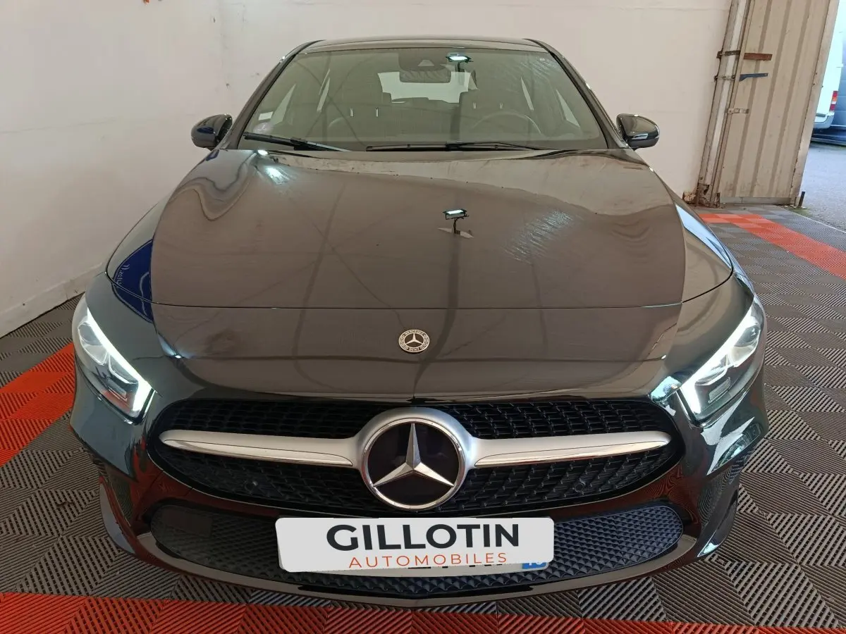 Vue avant d'une Mercedes Classe A 200 Business Line noire avec calandre chromée et phares LED allumés.