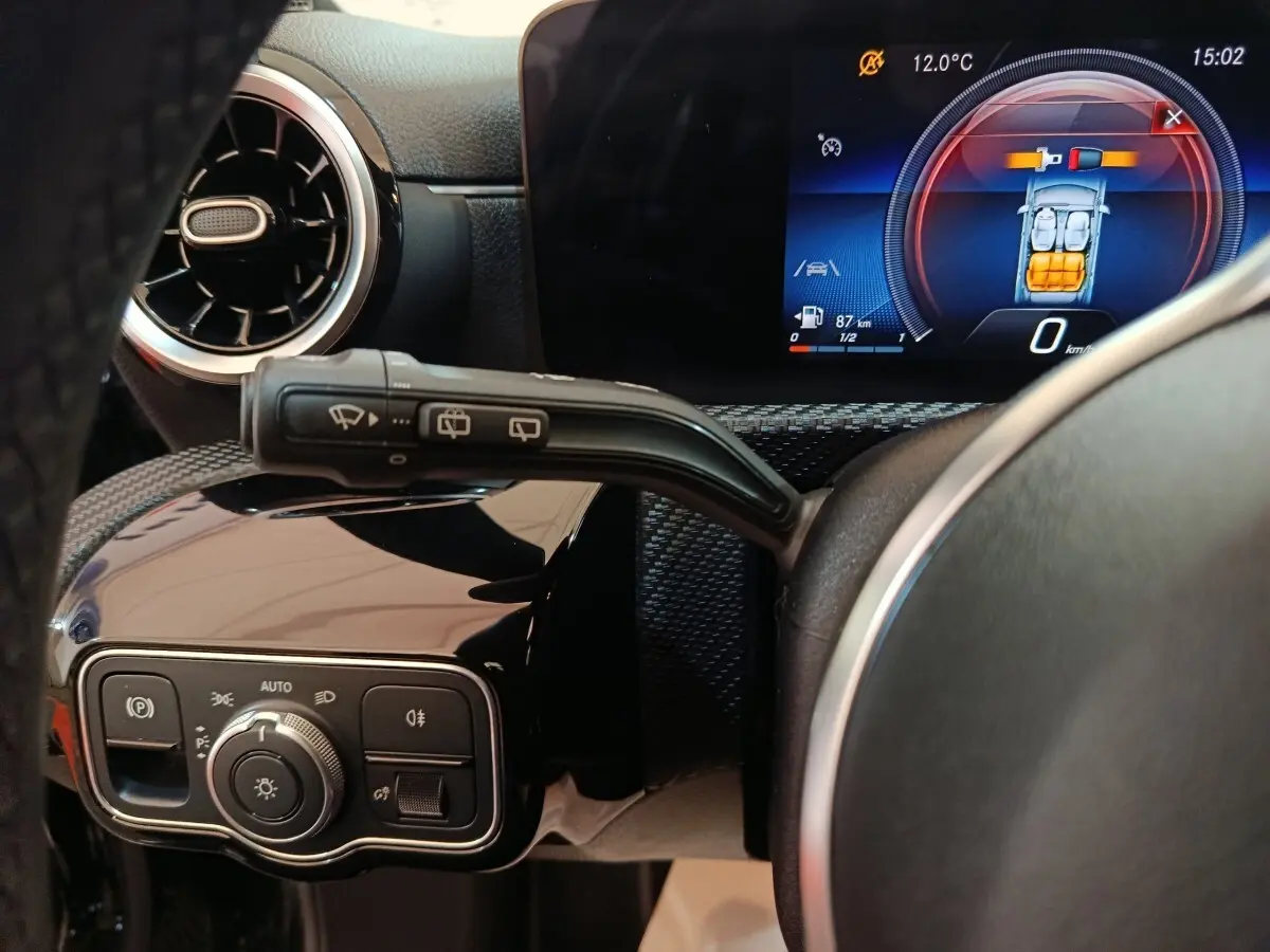 Vue rapprochée du tableau de bord noir de la Mercedes Classe A 200 Business Line, avec écran digital et commandes éclairage.