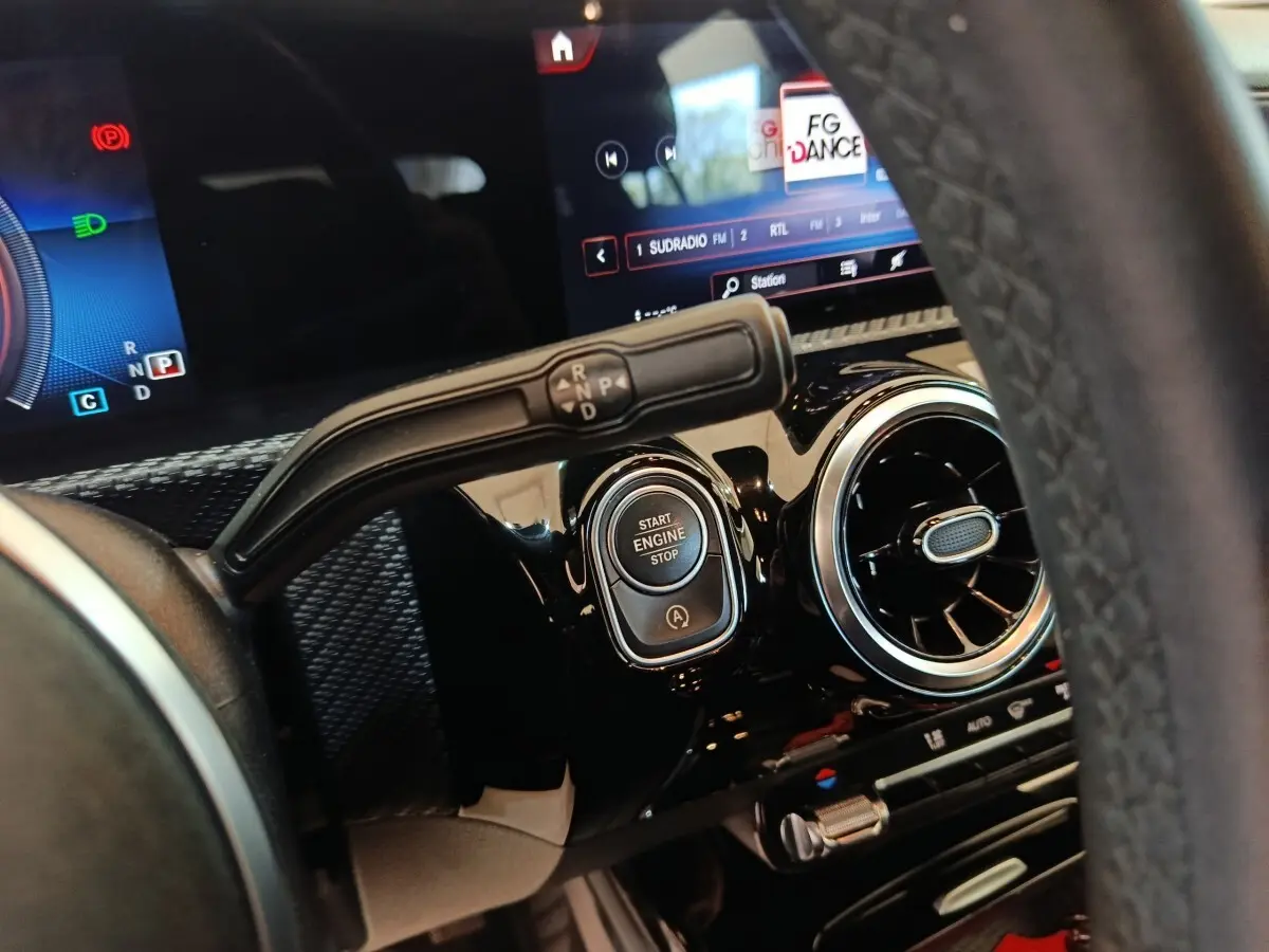 Gros plan intérieur sur le tableau de bord noir de la Mercedes Classe A 200, avec bouton start/stop et levier de vitesses.